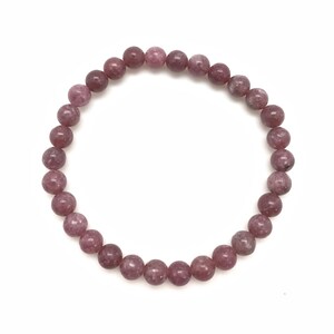 Puede incluir: Un brazalete de piedras preciosas rosa y blancas con cuentas redondas.