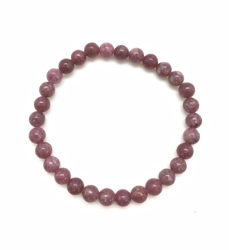 Puede incluir: Un brazalete de piedras preciosas rosa y blancas con cuentas redondas.