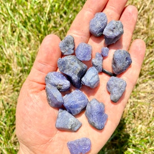 May include: A collection of raw, rough, blue kyanite crystals in various sizes and shapes. The crystals are a deep blue color with some natural inclusions.