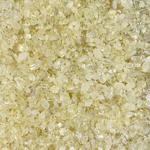 May include: A close-up image of a pile of small, translucent, yellow-tinted stones. The stones are smooth and have a natural, organic look.