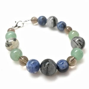May include: A bracelet made with green, blue, and gray gemstone beads. The bracelet has a silver clasp.
