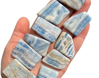 May include: A collection of ten blue and white banded polished blue calcite tumbled stones. The stones are various shapes and sizes and have a natural, organic look.