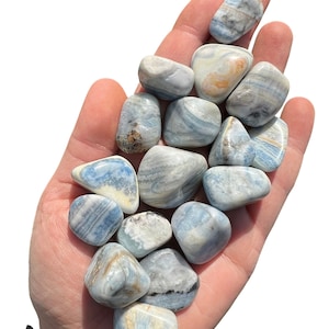 May include: A collection of blue and white banded tumbled stones. The stones are smooth and polished, with a variety of patterns and swirls.