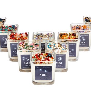 May include: Twelve glass candle jars with white wax and crystals inside. Each jar has a label with a zodiac sign and the dates for that sign. The signs are Aries, Taurus, Gemini, Cancer, Leo, Virgo, Libra, Scorpio, Sagittarius, Capricorn, Aquarius, and Pisces.