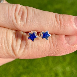 Peut inclure: Une paire de boucles d'oreilles en forme d'étoile argentées avec des pierres de lapis-lazuli bleues.