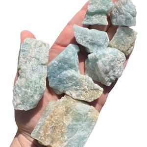 a hand holding a bunch of blue and yellow rocks