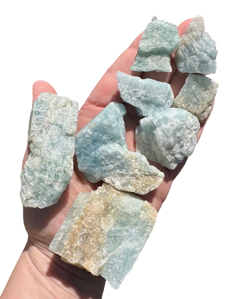 a hand holding a bunch of blue and yellow rocks