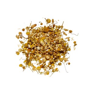 May include: A pile of dried chamomile flowers, featuring small, yellow, daisy-like blossoms and delicate stems. The dried herbs are a mix of light and dark brown, with a few white petals scattered throughout. The image is set against a clean white background.