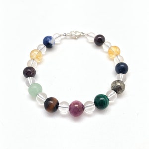 May include: A bracelet made with clear quartz, tiger's eye, amethyst, pyrite, sodalite, aventurine, and garnet beads. The bracelet has a silver clasp.