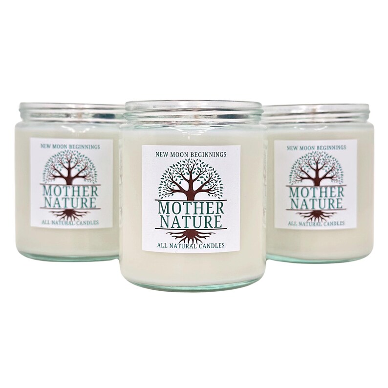 May include: Three glass candle jars with white labels. Each label has a green tree with brown branches and the text "NEW MOON BEGINNINGS" at the top. The text "MOTHER NATURE" is in a larger font below the tree. The text "ALL NATURAL CANDLES" is in a smaller font below the larger text.