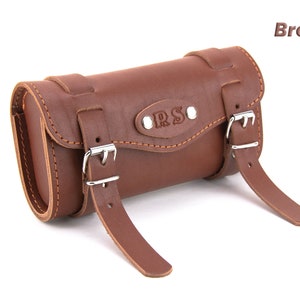 May include: Brown leather bicycle handlebar bag with two buckles and the letters "R.S." embossed on the front.