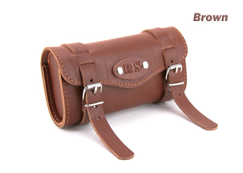 May include: Brown leather bicycle handlebar bag with two buckles and the letters "R.S." embossed on the front.