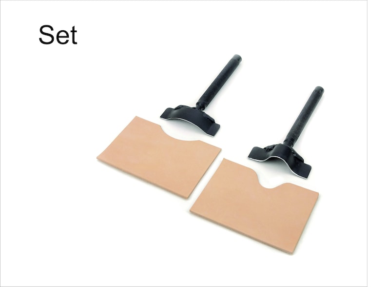 May include: Set of two leather craft tools with two pieces of leather. The tools are black and have a curved metal blade. The leather is light brown.