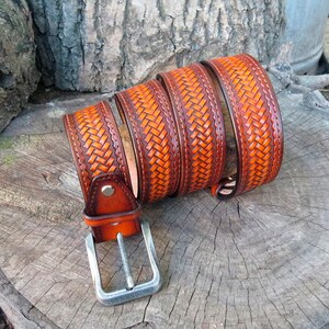 May include: A brown leather belt with a woven design and a silver buckle.