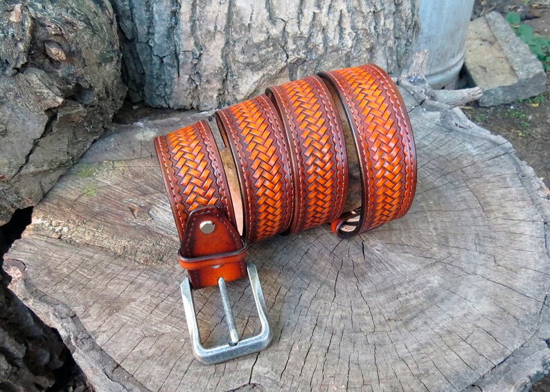 May include: A brown leather belt with a woven design and a silver buckle.