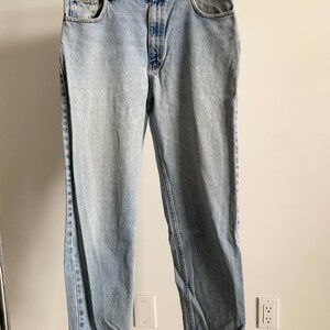 Peut inclure: Un jean en denim bleu clair à jambe droite. Le jean a une braguette à boutons et cinq poches.