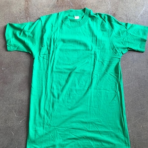Puede incluir: Una camiseta lisa de color verde con mangas cortas.