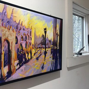 May include: A framed painting of a city street scene with tall buildings, a yellow sky, and people walking on the sidewalk. The painting is done in a colorful, impressionistic style.