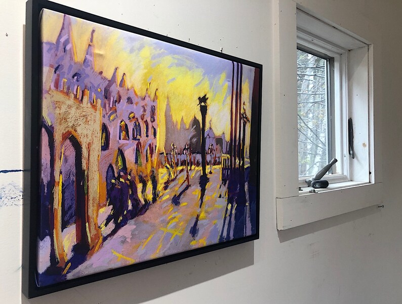 May include: A framed painting of a city street scene with tall buildings, a yellow sky, and people walking on the sidewalk. The painting is done in a colorful, impressionistic style.