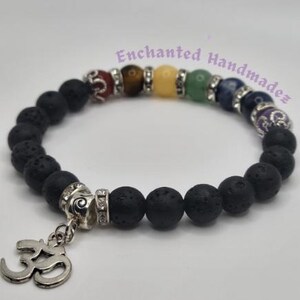 Può includere: Braccialetto con perline di roccia vulcanica nera con un ciondolo Om argentato e sette pietre dei chakra: rosso, arancione, giallo, verde, blu, indaco e viola.