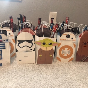 Puede incluir: Un conjunto de 10 bolsas de regalo con tem&aacute;tica de Star Wars. Las bolsas son blancas con diferentes personajes de Star Wars impresos en ellas, incluyendo R2-D2, un Stormtrooper, Yoda, BB-8 y Chewbacca. Cada bolsa tiene un asa y est&aacute; llena de caramelos.