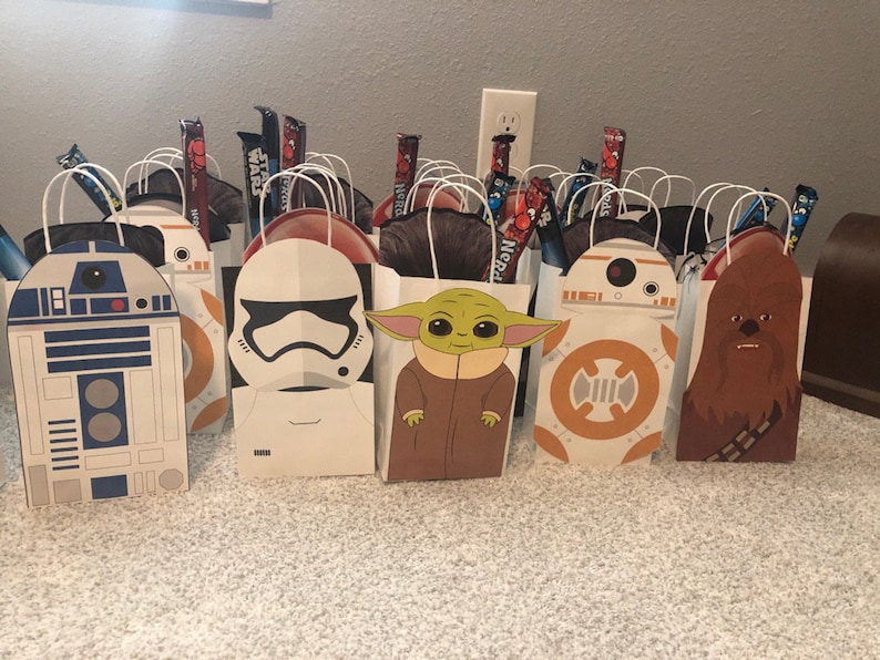 Puede incluir: Un conjunto de 10 bolsas de regalo con tem&aacute;tica de Star Wars. Las bolsas son blancas con diferentes personajes de Star Wars impresos en ellas, incluyendo R2-D2, un Stormtrooper, Yoda, BB-8 y Chewbacca. Cada bolsa tiene un asa y est&aacute; llena de caramelos.