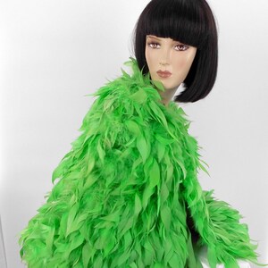 May include: A bright green feather boa with a long, flowing design. The boa is made of soft, fluffy feathers and is perfect for adding a touch of glamour to any outfit.