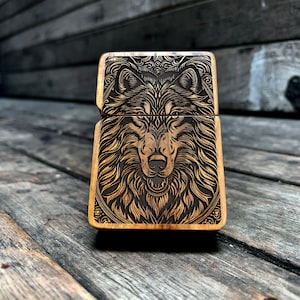 May include: A wooden lighter with a detailed engraved design of a wolf's face. The wolf's fur is intricately carved, and its eyes are black.