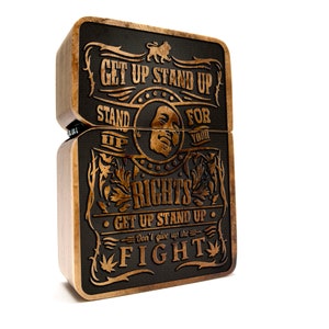 Könnte beinhalten: Eine Holzkiste mit schwarzem Hintergrund und goldenen Lettern. Die Kiste trägt den Text "Get Up Stand Up Stand Up For Your Rights Get Up Stand Up Don't Give Up The Fight".