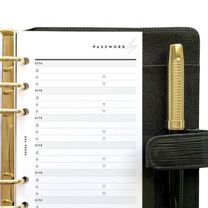 May include: Black leather-bound planner with gold-tone hardware and a matching pen. The planner is open to reveal lined pages for recording passwords, with the word "PASSWORD" printed at the top. A gold-tone bookmark is visible.