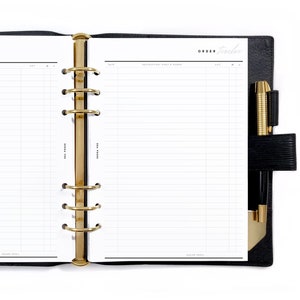 May include: An open black planner with gold rings and a pen holder. The planner has lined pages with the words "ORDER tracker" at the top.