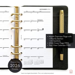May include: A black personal size 2026 printable planner with gold accents. The planner is open to a November 2026 calendar page. A gold pen is secured in the planner's holder. The planner includes a month overview page, checklists, and a cover page.