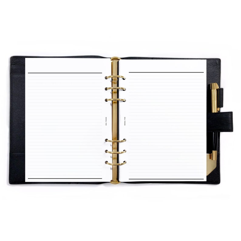 May include: A black leather bound planner with gold rings and a pen holder. The planner is open to a blank page with lined paper.