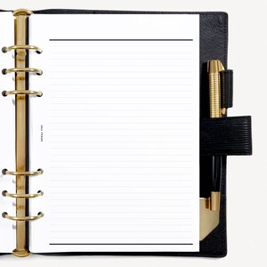 May include: A black leather bound planner with gold rings and a white lined page. A gold pen is in the pen holder.