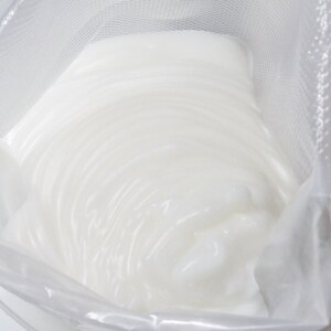 May include: A white, creamy substance in a clear plastic bag with a mesh lining.