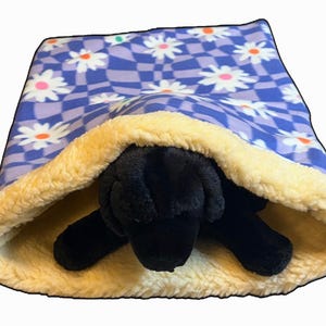 May include: A white ceramic mug with a black handle and the text "But First, Coffee" in a bold, black font. The mug is set against a blurred background, highlighting its clean design.