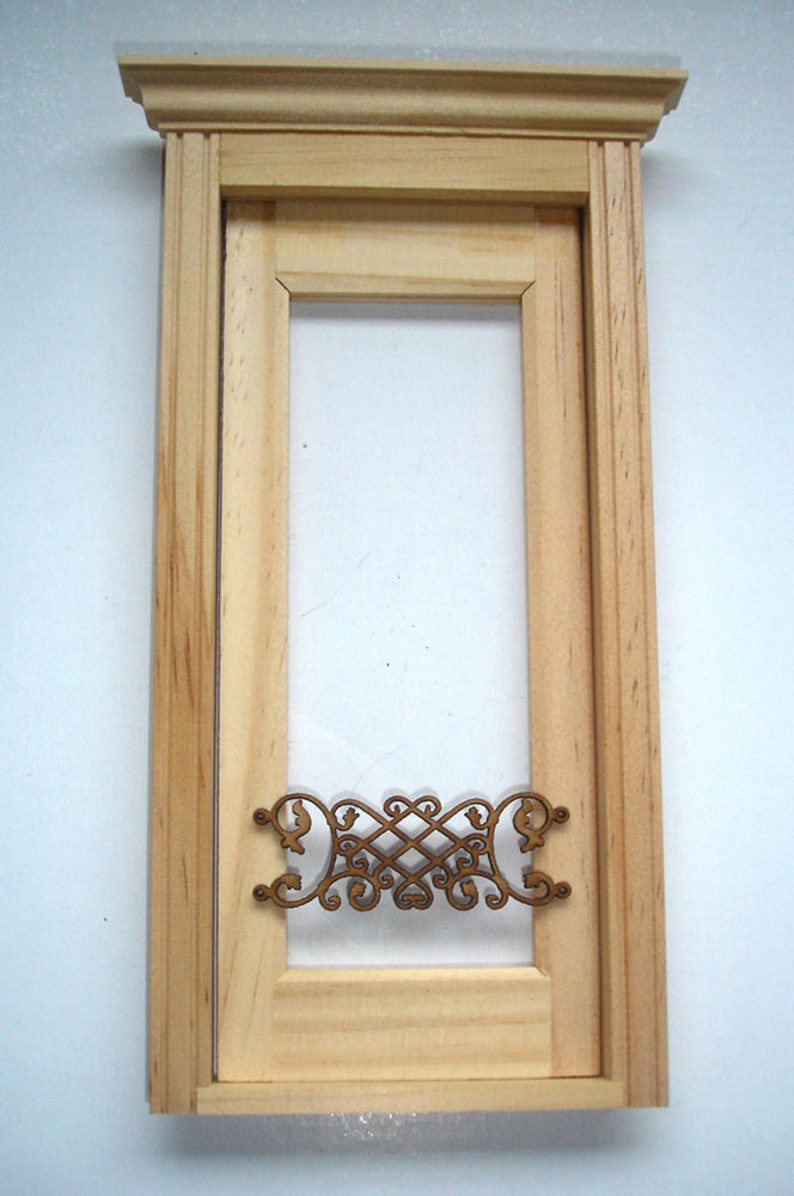 Puede incluir: Un marco de puerta de madera con una reja met&aacute;lica decorativa. El marco est&aacute; hecho de madera sin terminar y tiene un dise&ntilde;o simple. La reja est&aacute; hecha de metal y tiene un dise&ntilde;o decorativo.