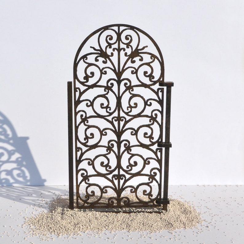 Puede incluir: Una puerta de metal decorativa con un dise&ntilde;o de desplazamiento. La puerta est&aacute; hecha de metal negro y tiene un estilo tradicional.