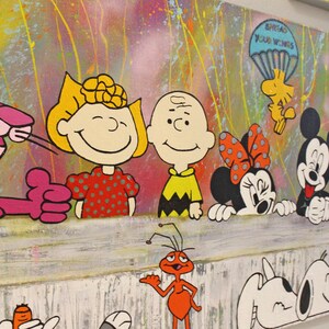 Pu&ograve; includere: Un dipinto colorato con personaggi dei cartoni animati tra cui la Pantera Rosa, Charlie Brown, Snoopy, Topolino e Minnie, e Kermit la Rana. Lo sfondo presenta schizzi di vernice colorati.