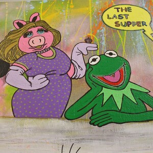 Pu&ograve; includere: Un dipinto colorato con personaggi dei cartoni animati in una parodia dell'Ultima Cena. Miss Piggy e Kermit la Rana sono al centro, con Topolino e Darth Vader ai lati. Il testo "THE LAST SUPPER" &egrave; in un fumetto.
