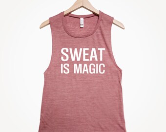 Puede incluir: Un top sin mangas de color rosa jaspeado con el texto "SWEAT IS MAGIC" impreso en blanco en la parte delantera.