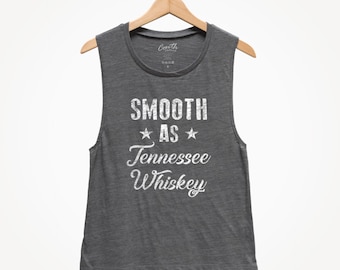 May include: Gray sleeveless tank top with the text "SMOOTH AS Tennessee Whiskey" in white with a distressed look.