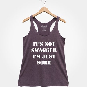 K&ouml;nnte beinhalten: Ein lilafarbenes Tanktop mit dem Aufdruck "IT'S NOT SWAGGER I'M JUST SORE" in wei&szlig;.