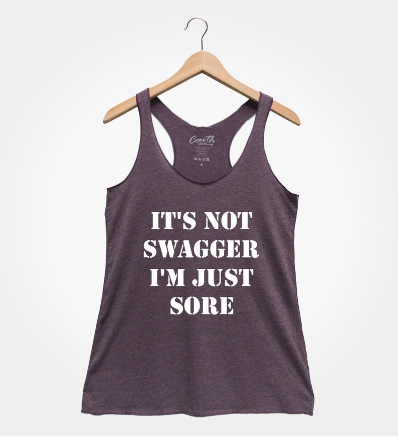 K&ouml;nnte beinhalten: Ein lilafarbenes Tanktop mit dem Aufdruck "IT'S NOT SWAGGER I'M JUST SORE" in wei&szlig;.