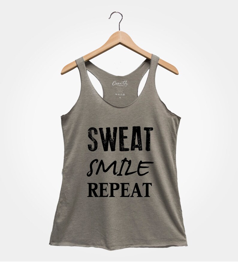 May include: A heather grey tank top with a black graphic that reads "Sweat Smile Repeat".