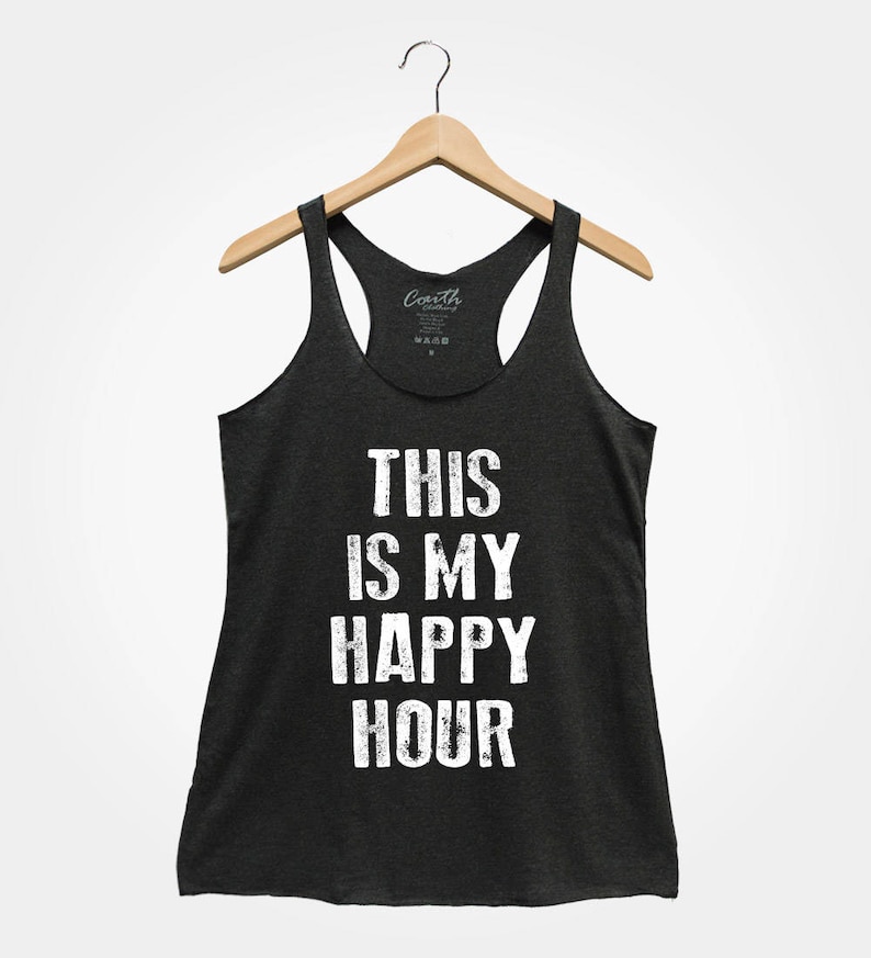 Puede incluir: Un top de tirantes gris oscuro con el texto "This is my happy hour" impreso en blanco. El texto tiene un aspecto desgastado y vintage.