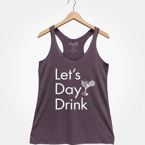 May include: A purple racerback tank top with the text "Let's Day Drink" and a white silhouette of a margarita glass with a lime wedge.