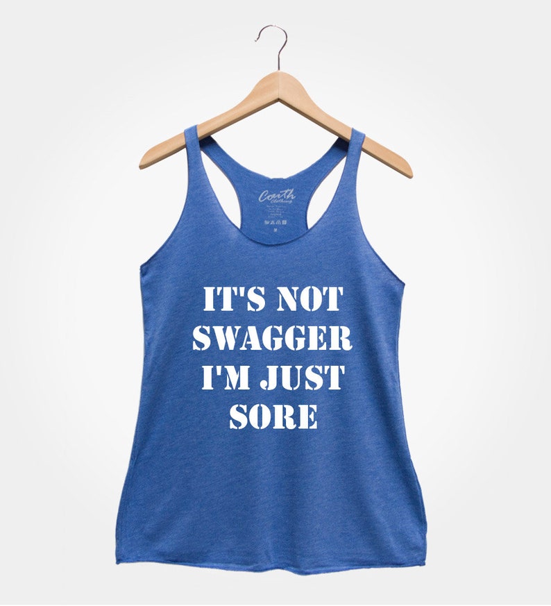 K&ouml;nnte beinhalten: Ein blaues Racerback-Tanktop mit dem Text "It's not swagger I'm just sore" in Wei&szlig;.