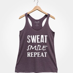 May include: A purple tank top with the text "SWEAT SMILE REPEAT" in white.