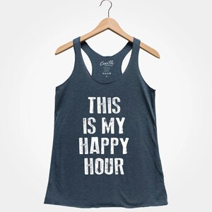 Puede incluir: Un top de tirantes azul oscuro con el texto "This is my happy hour" impreso en blanco en la parte delantera.